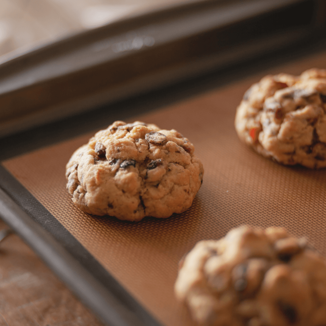 Freshly baked chocolate chip cookies from Ramadan Bundle Box mix on brown baking mat showing texture and melted chips