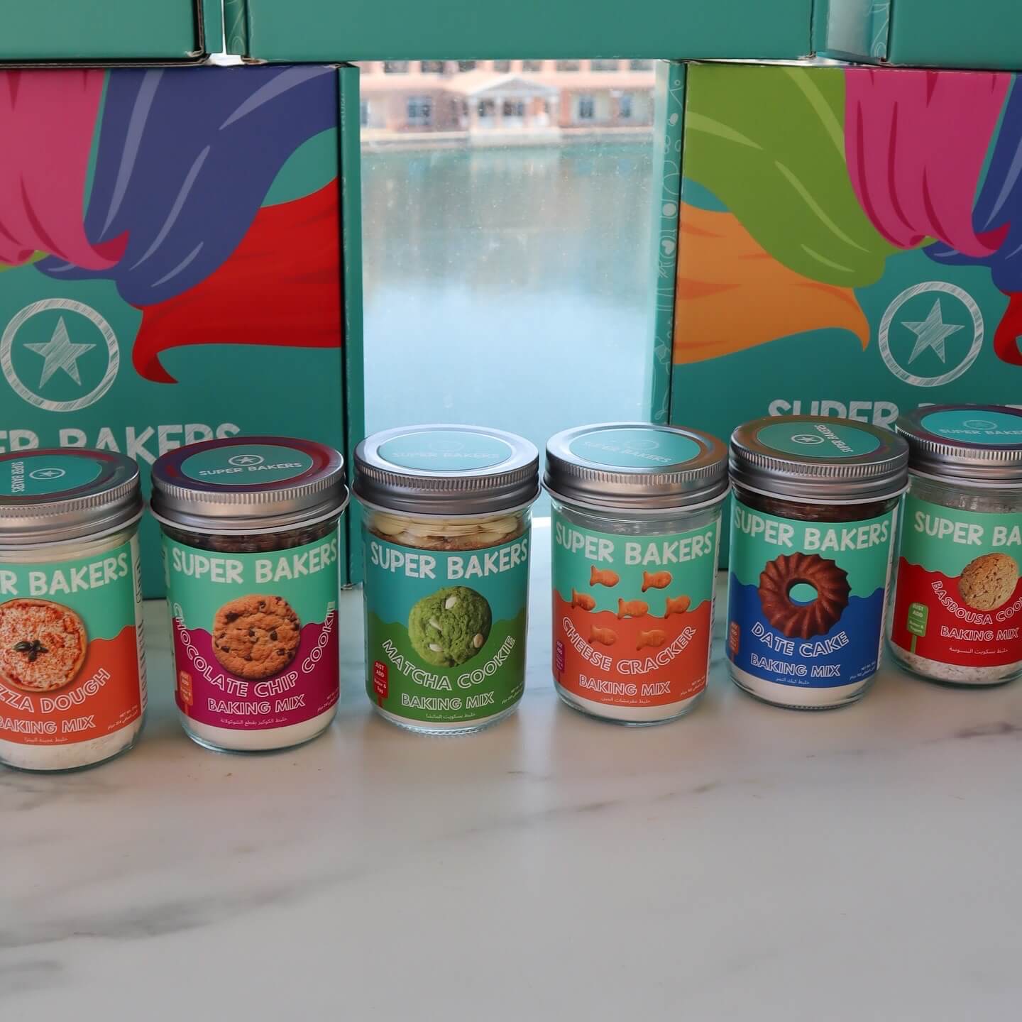 Line up of baking mix Jars Matcha Pizza dough Chocolate chip cheese Datecake Basbousa cookie